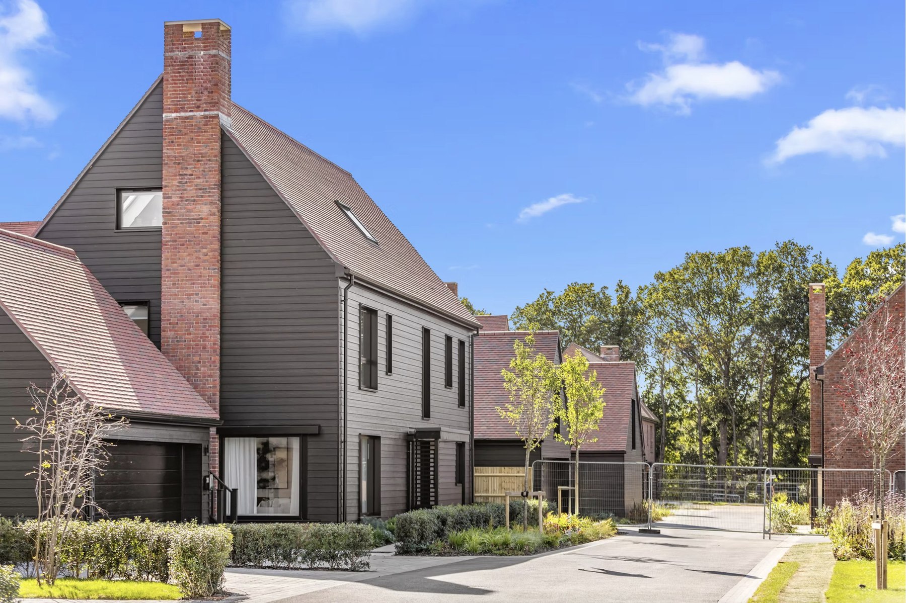 Alfold Gardens street view of contemporary family homes with dark cladding and landscaping, Surrey