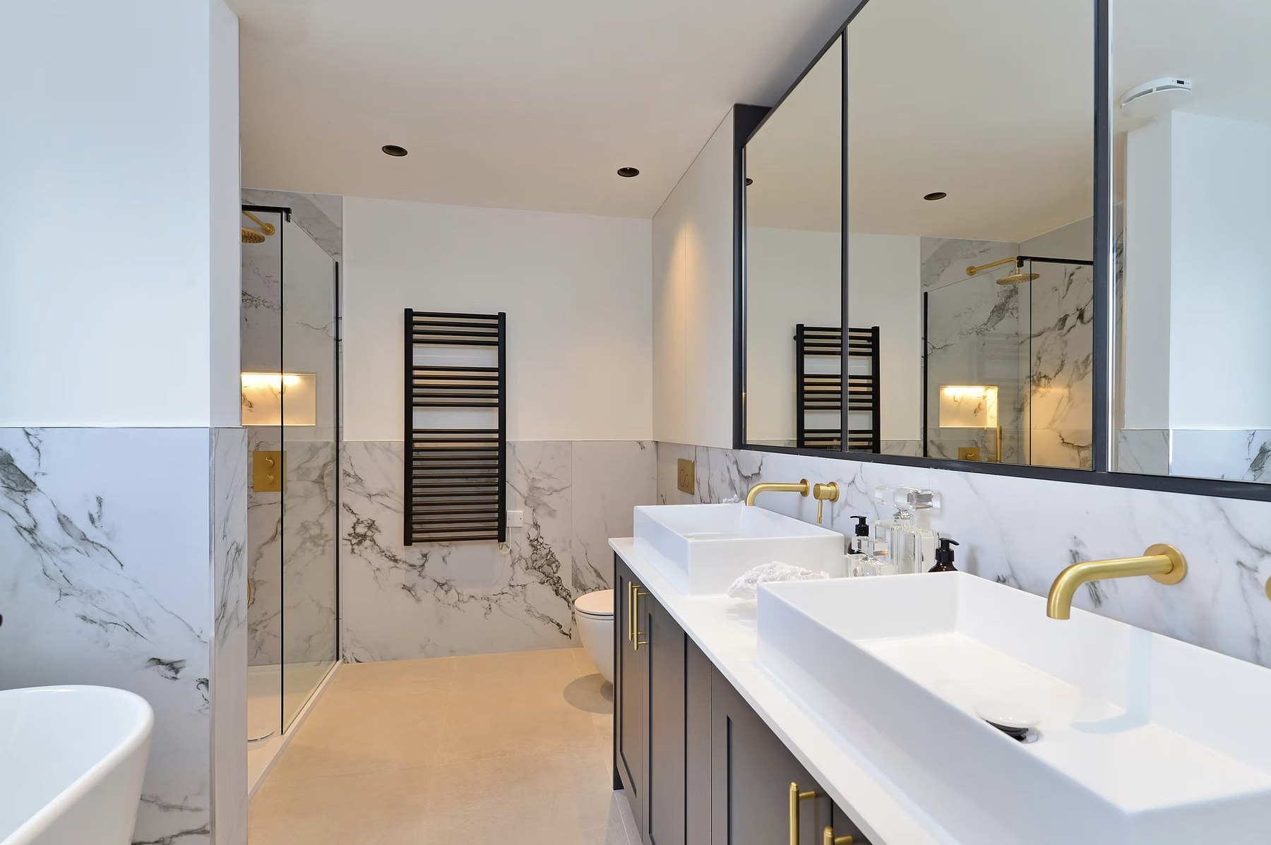 Alfold Gardens completed primary bathroom with marble, dual basins and gold fixtures, Surrey — specification by HDEY