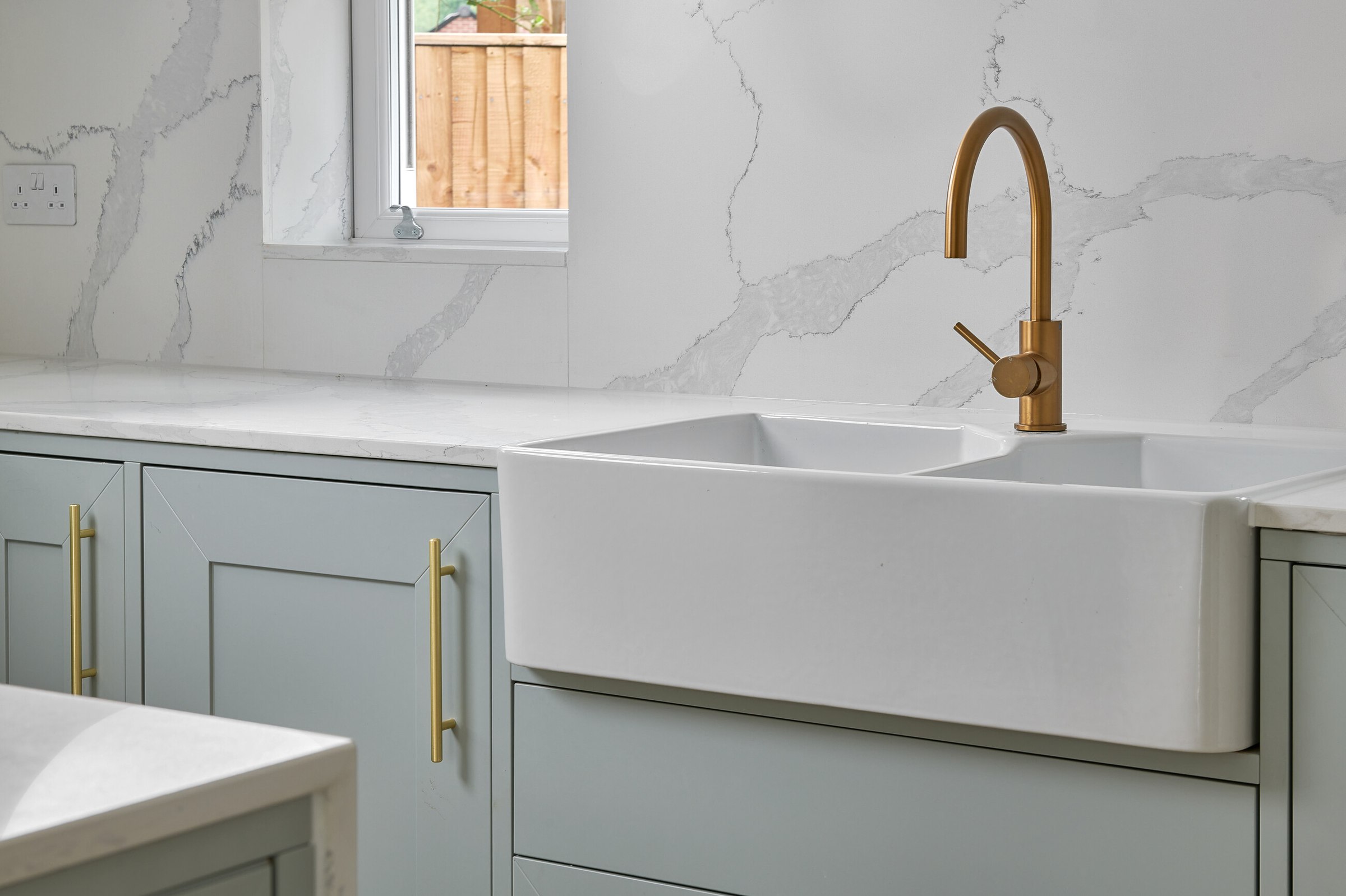 Brompton Gardens completed kitchen detail with sage units, brass tap and double Belfast sink, West End, Woking