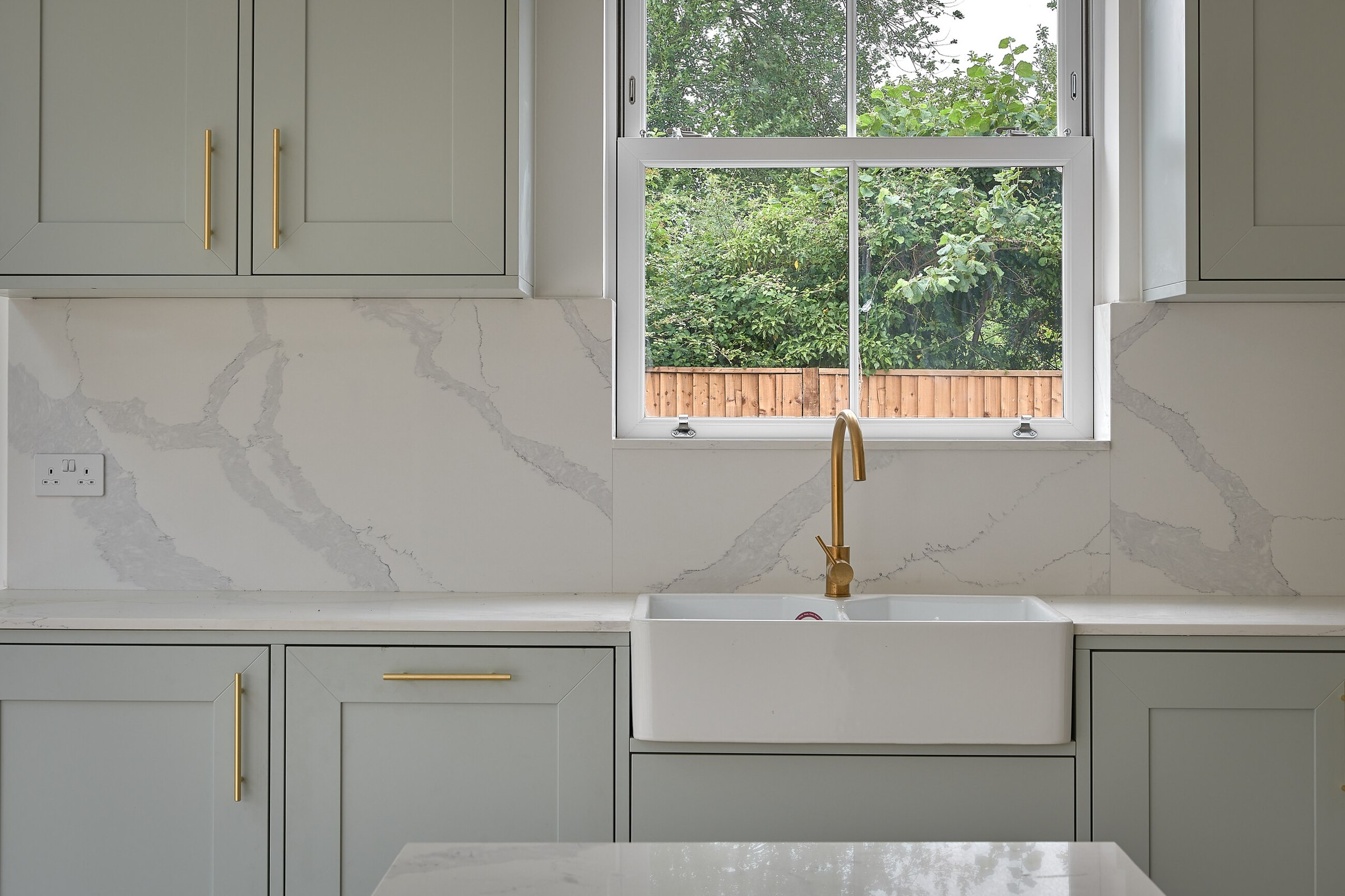 Brompton Gardens completed kitchen with sage units, stone upstand and sash window, West End, Woking