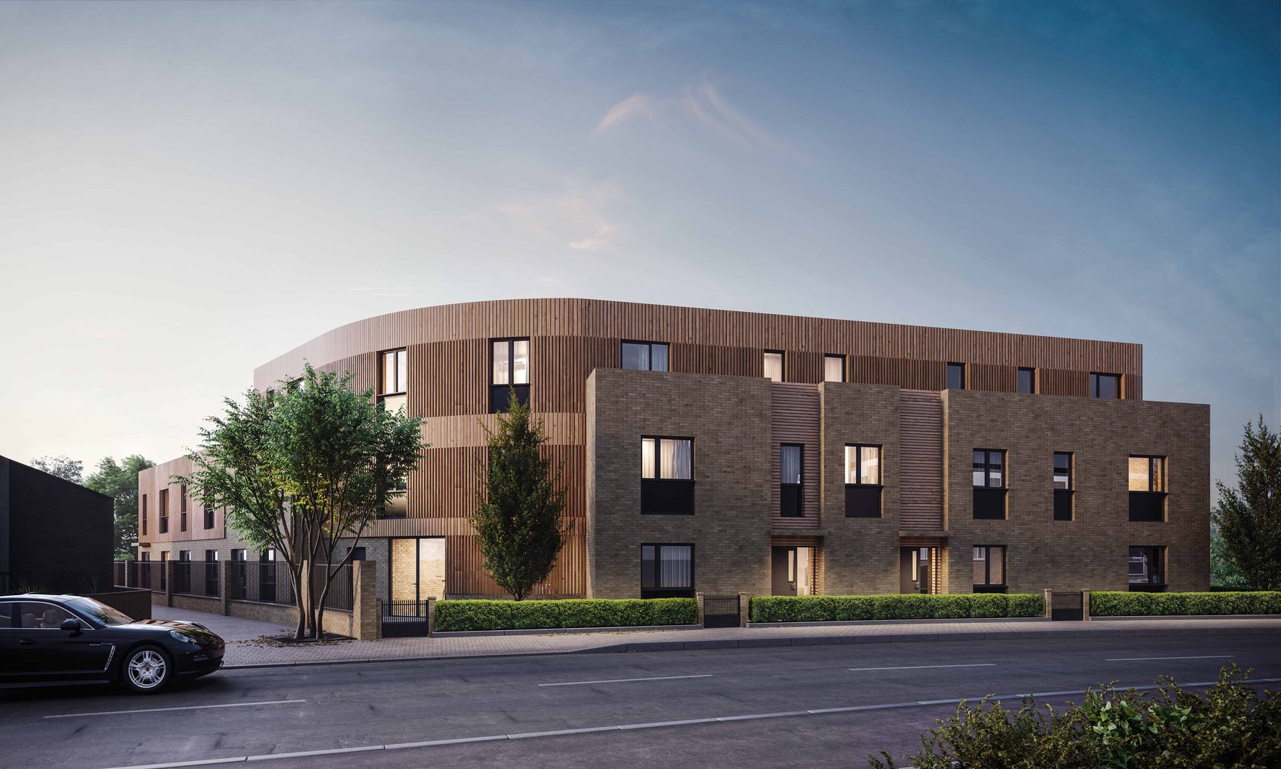 Castlepoint Residences external CGI at dusk — brick and vertical timber cladding on a curved corner elevation, Huntingdon — by HDEY