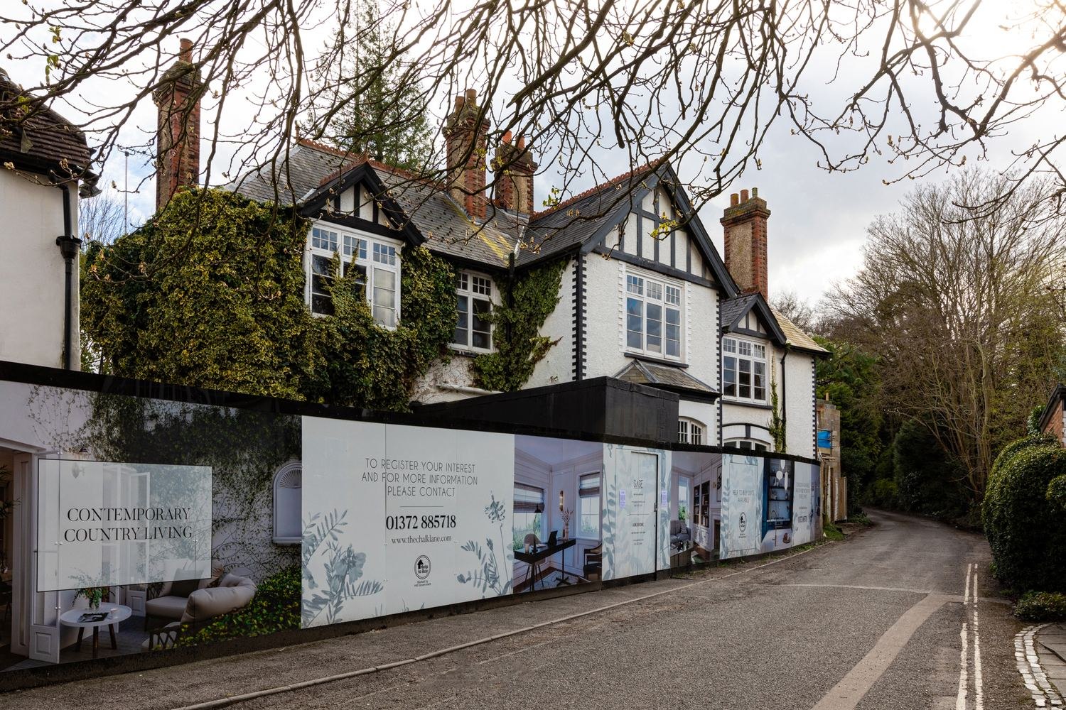 The Chalk Lane Residences hoarding reading contemporary country living, with the building behind, Epsom — by HDEY
