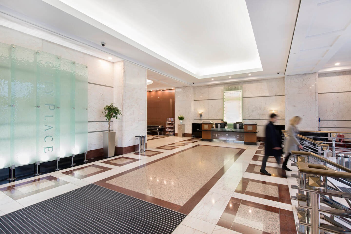 City Place House reception after refurbishment, with etched glass screens carrying the building name, planting and a rebuilt desk, City of London — by HDEY