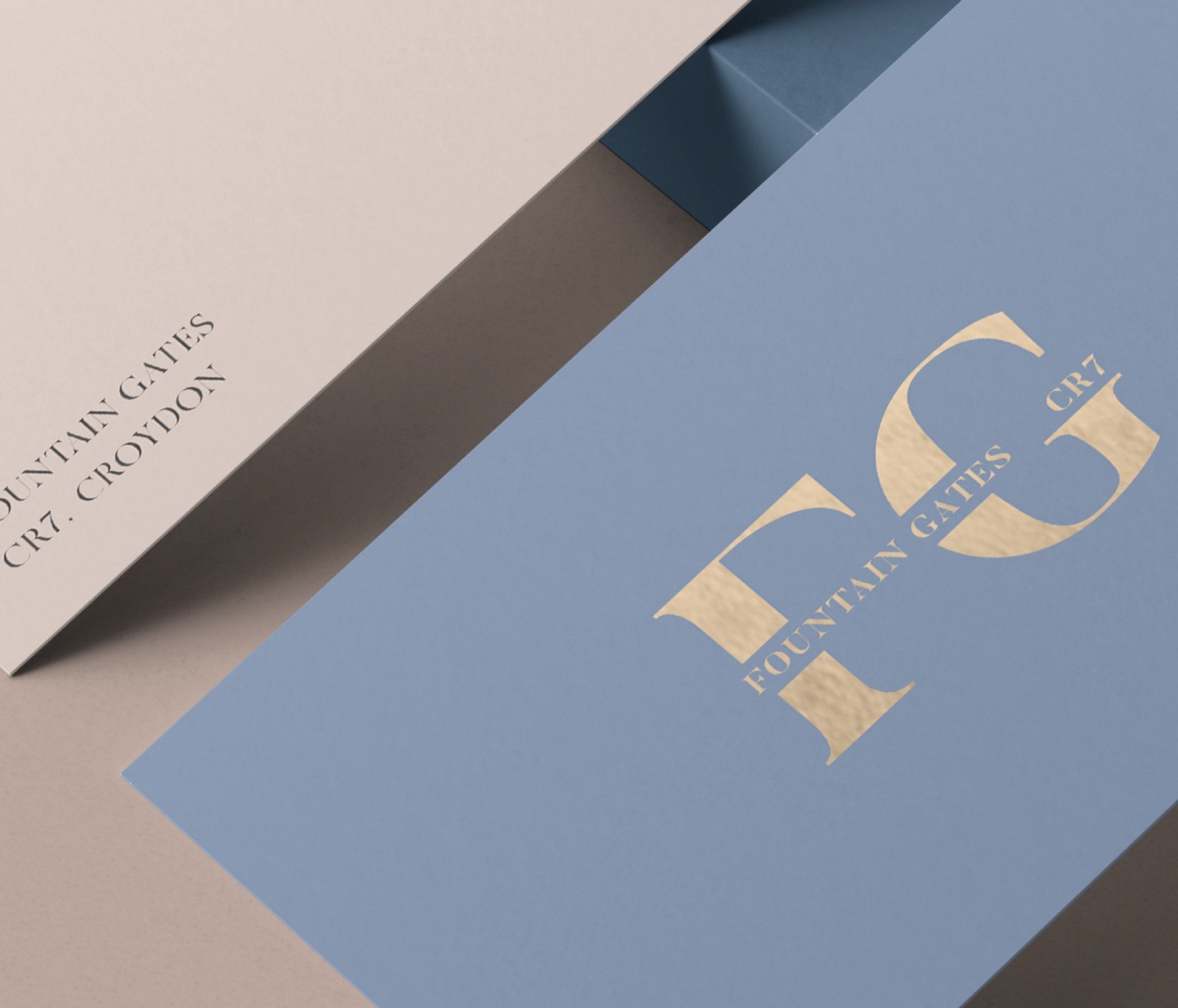 Fountain Gates FG monogram shown in gold on blue, with letterhead alongside — brand identity by HDEY