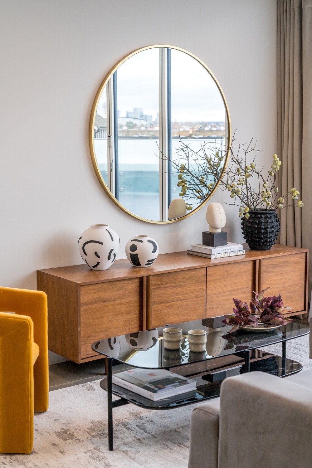 Hannell House show home living room with round mirror reflecting the London skyline, Fulham, by HDEY