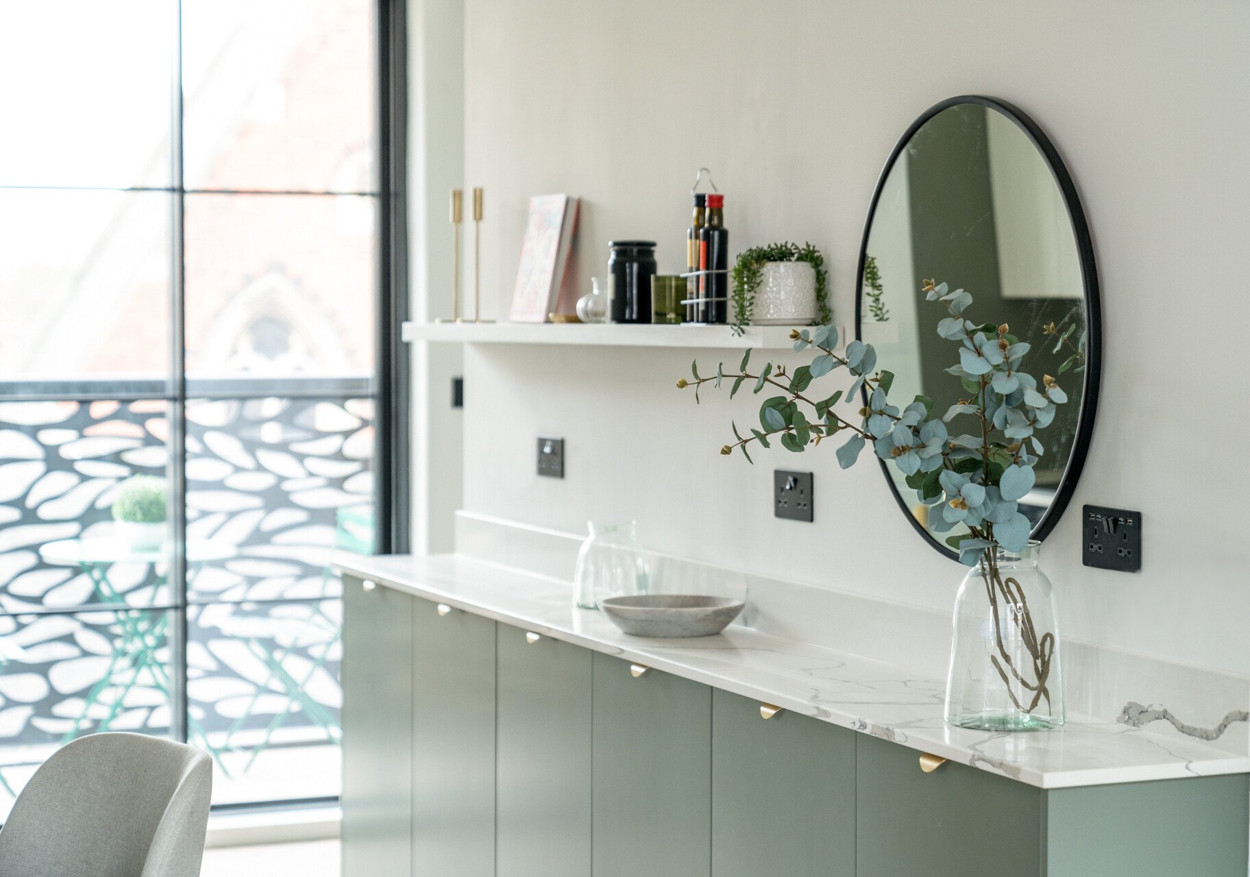 Market Place kitchen counter detail with round mirror and brass accents, Acton, by HDEY