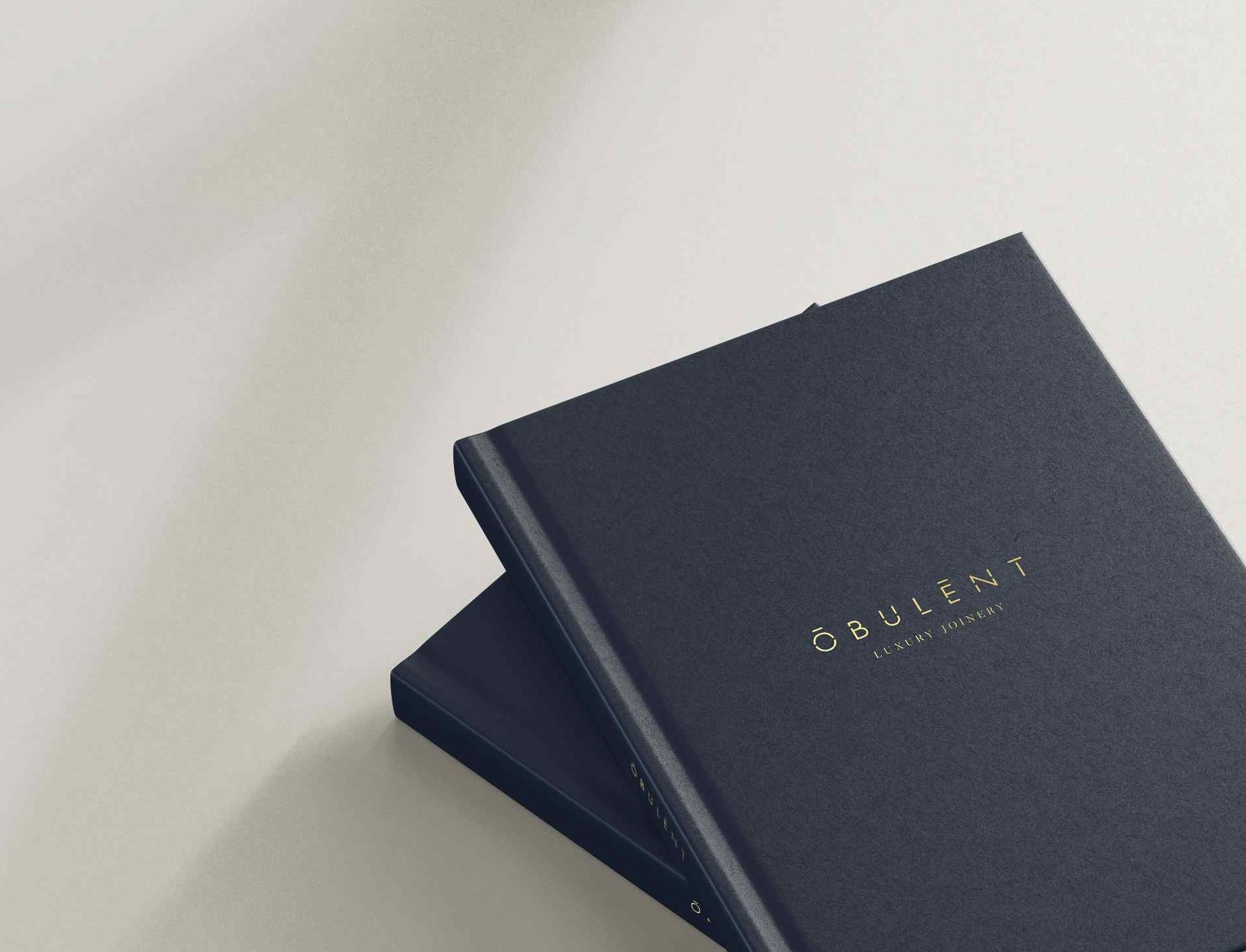Obulent brochure bound in navy cloth with the logotype and the words LUXURY JOINERY foiled in gold — brand identity by HDEY