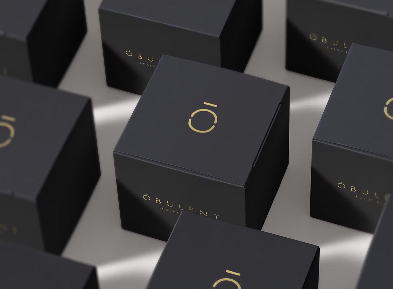 Obulent sample boxes in near-black with the gold logomark on the lid and the logotype on the side — packaging design by HDEY