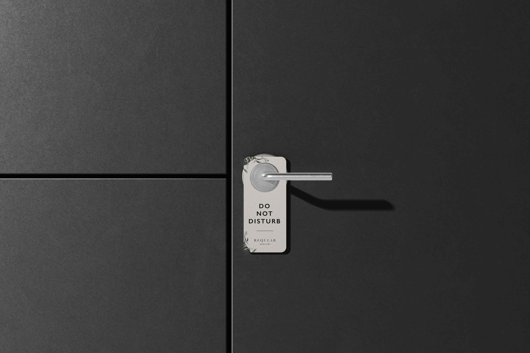 Reqular Do Not Disturb door hanger in off-white with the logotype beneath, hung on a black door, brand collateral by HDEY
