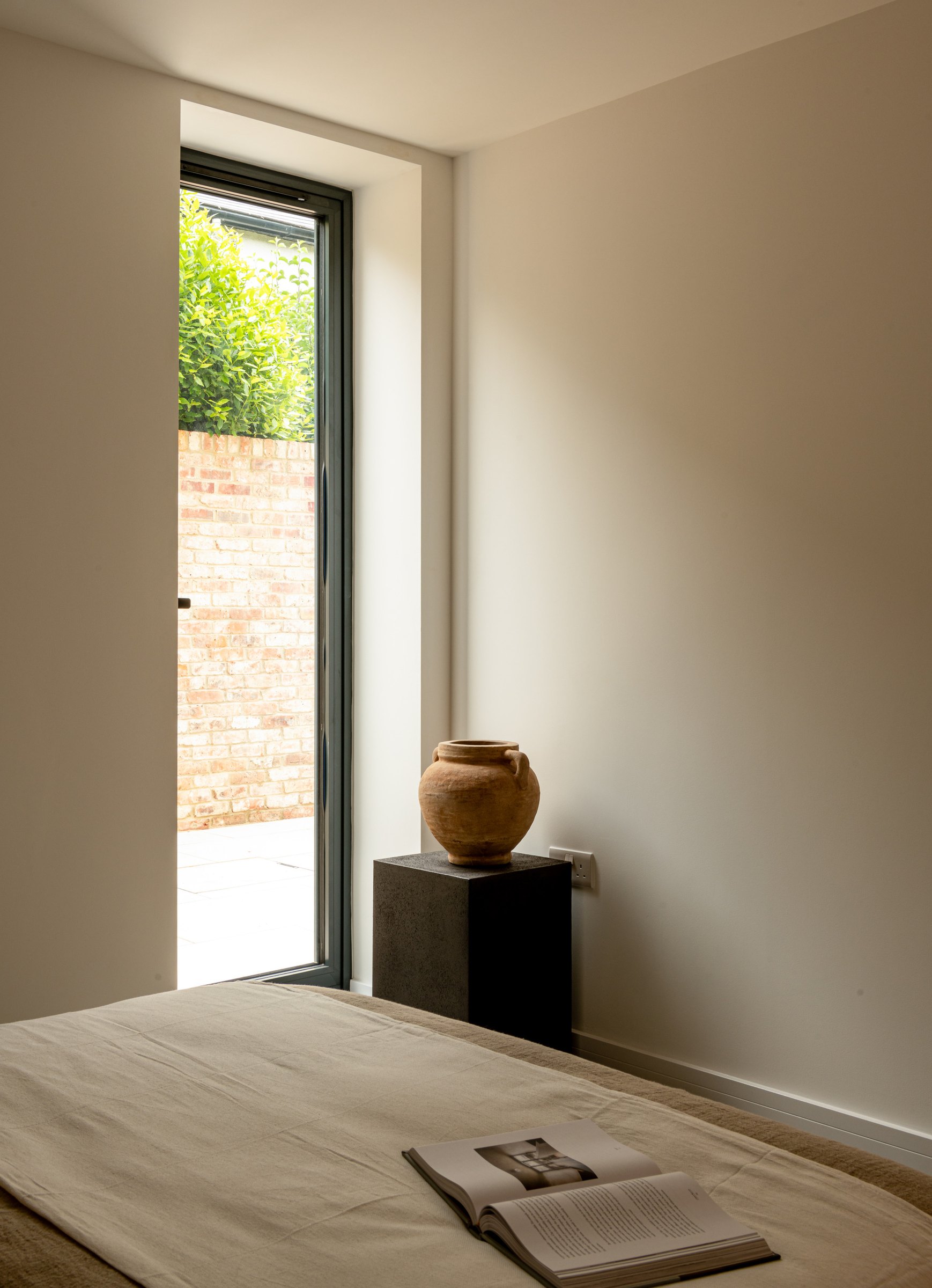 Robson Road show home bedroom with full-height glazing to the private courtyard, West Dulwich, styled by HDEY
