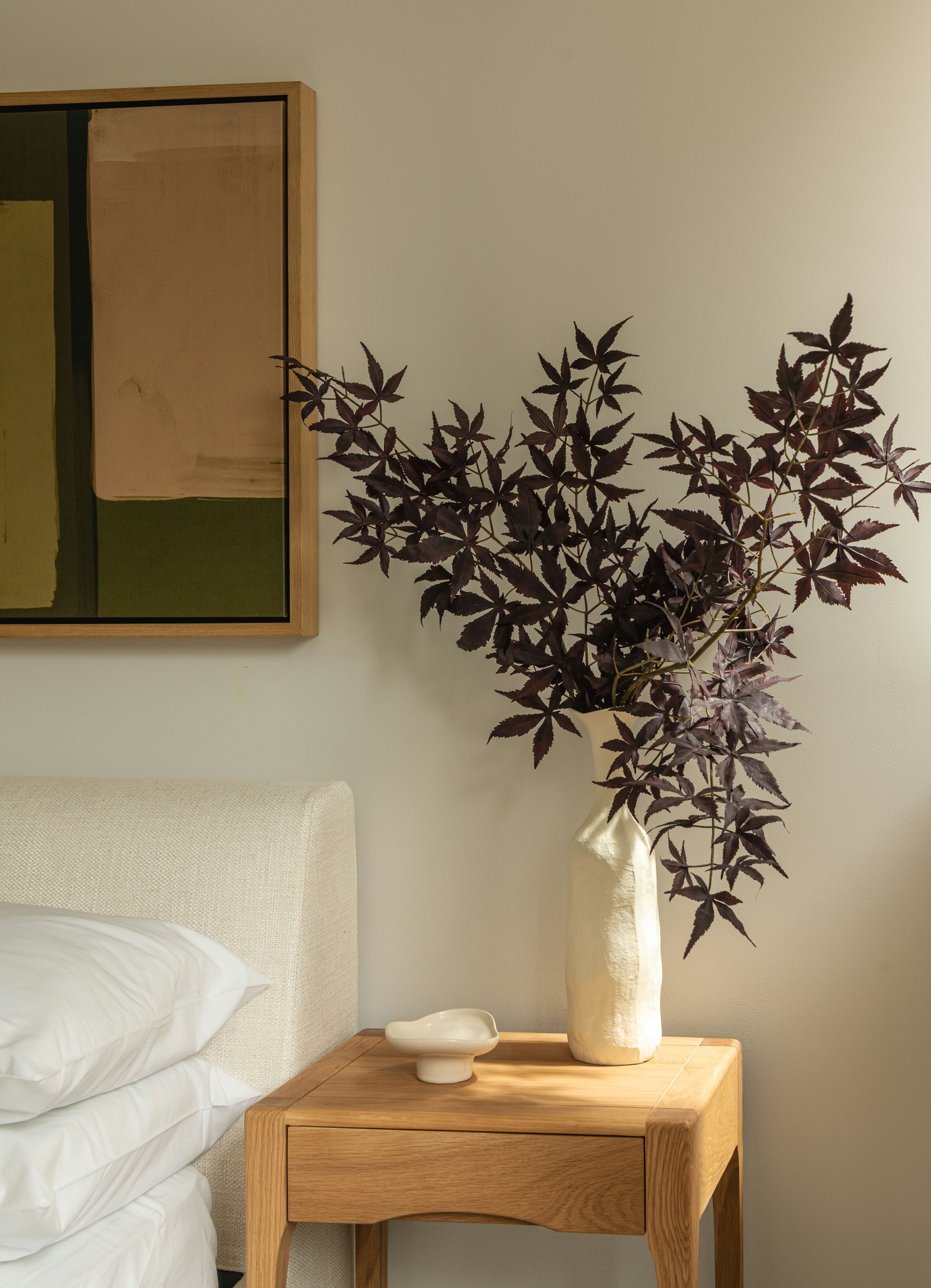 Robson Road show home bedside detail with oak table and seasonal foliage, West Dulwich, styled by HDEY