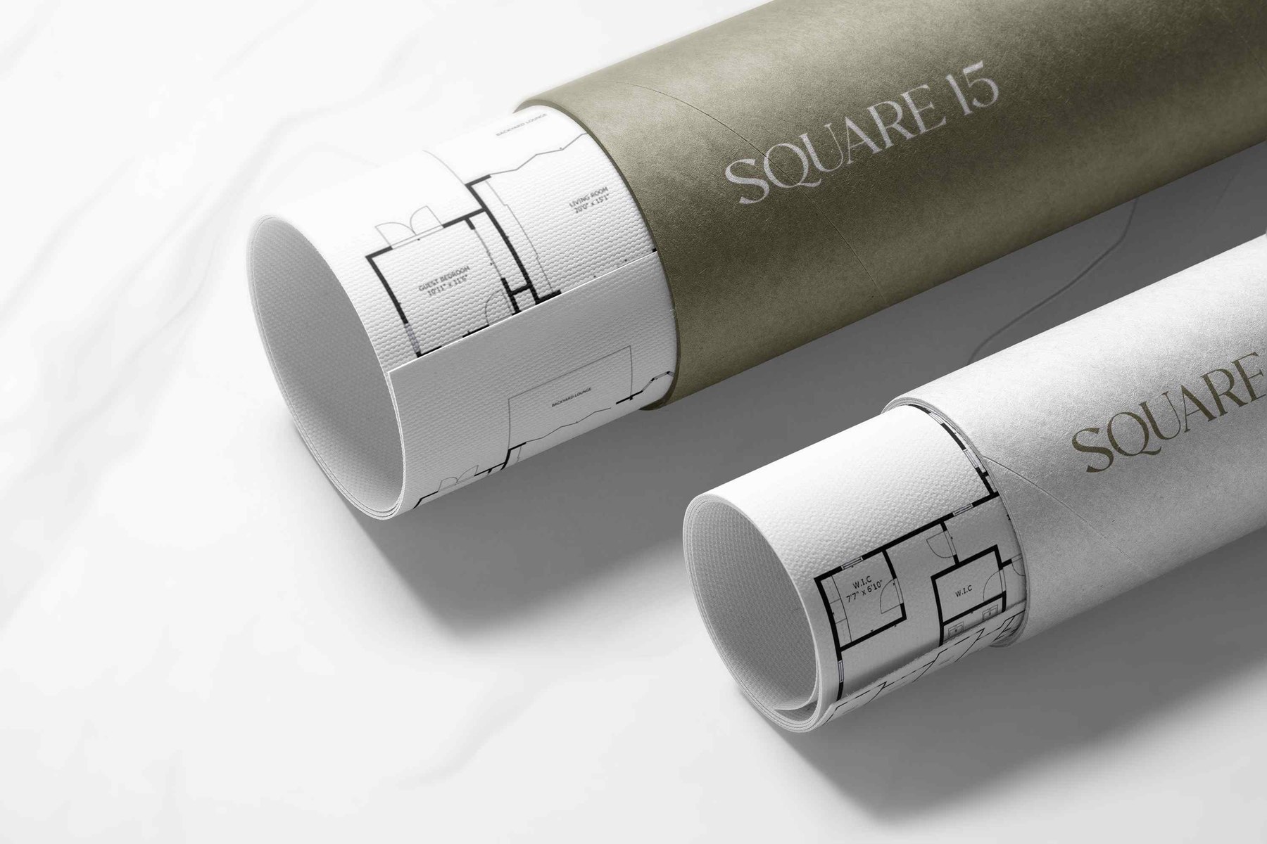 Square 15 branded drawing tubes in olive and off-white with floor plans rolled inside, brand materials by HDEY