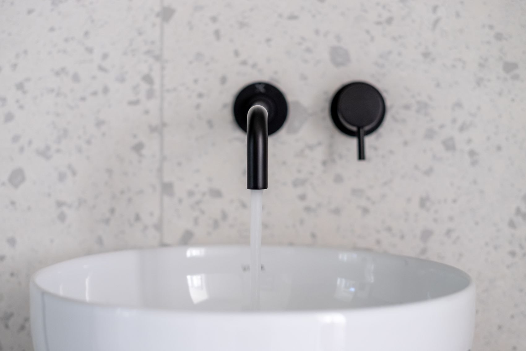 Streatley Road basin with black wall-mounted tap against terrazzo, London, specification by HDEY