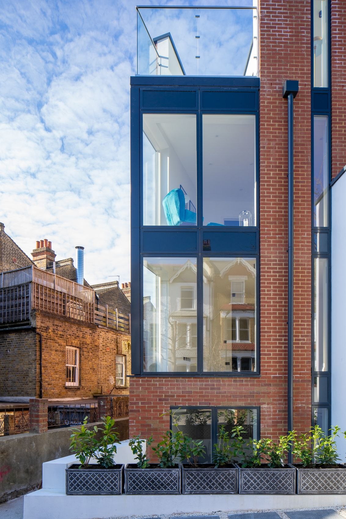 Streatley Road exterior with blue-framed glazing set into red brick, London
