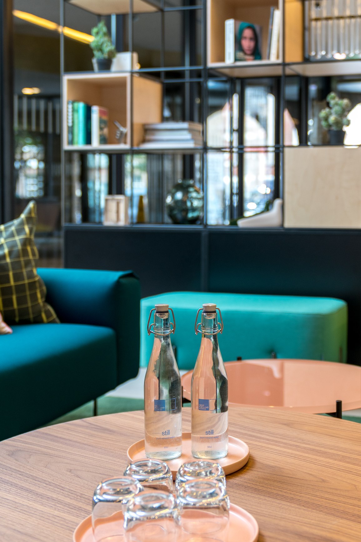Twenty styling detail with glass bottles on a blush tray and the plywood and metal shelving behind, London Bridge — styling by HDEY