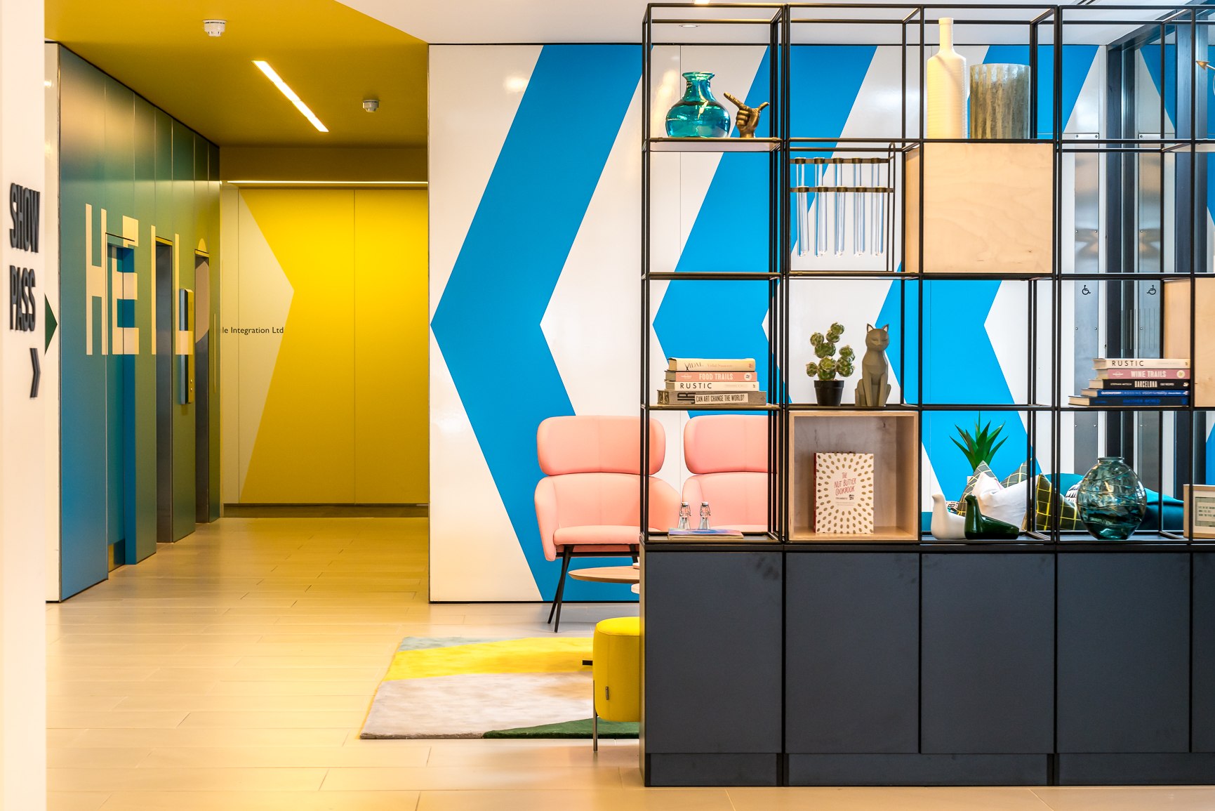 Twenty reception with blue chevrons, a black metal grid divider and coral armchairs, London Bridge — interior design by HDEY