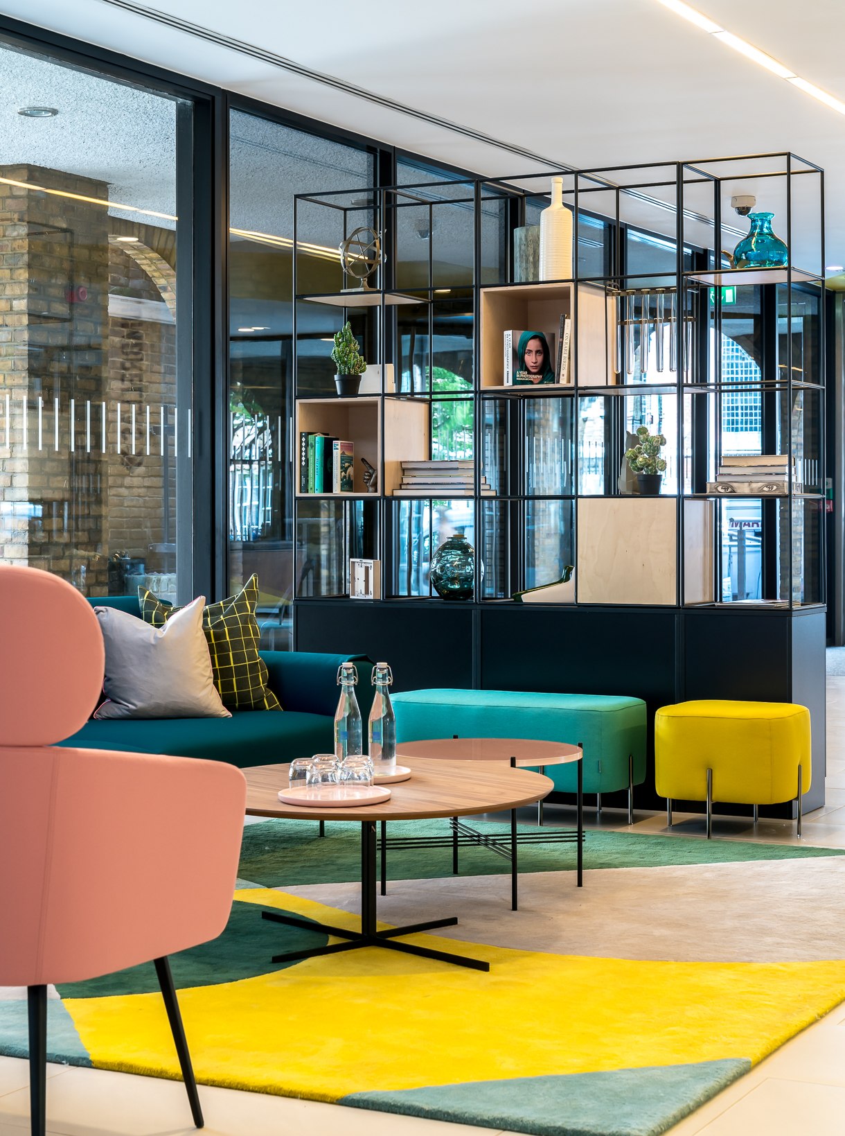 Twenty seating area with colour-block rug, teal bench, yellow stool and the metal grid divider, London Bridge — interior design by HDEY