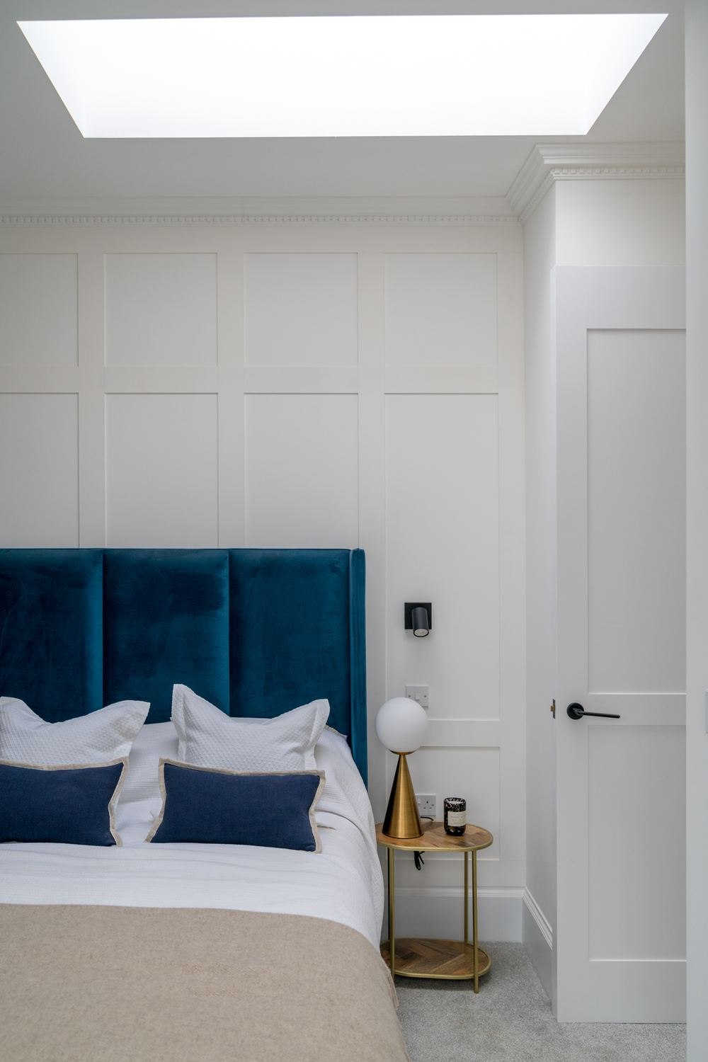 West Lodge bedroom with teal headboard, panelling and skylight, Ealing — interior design by HDEY