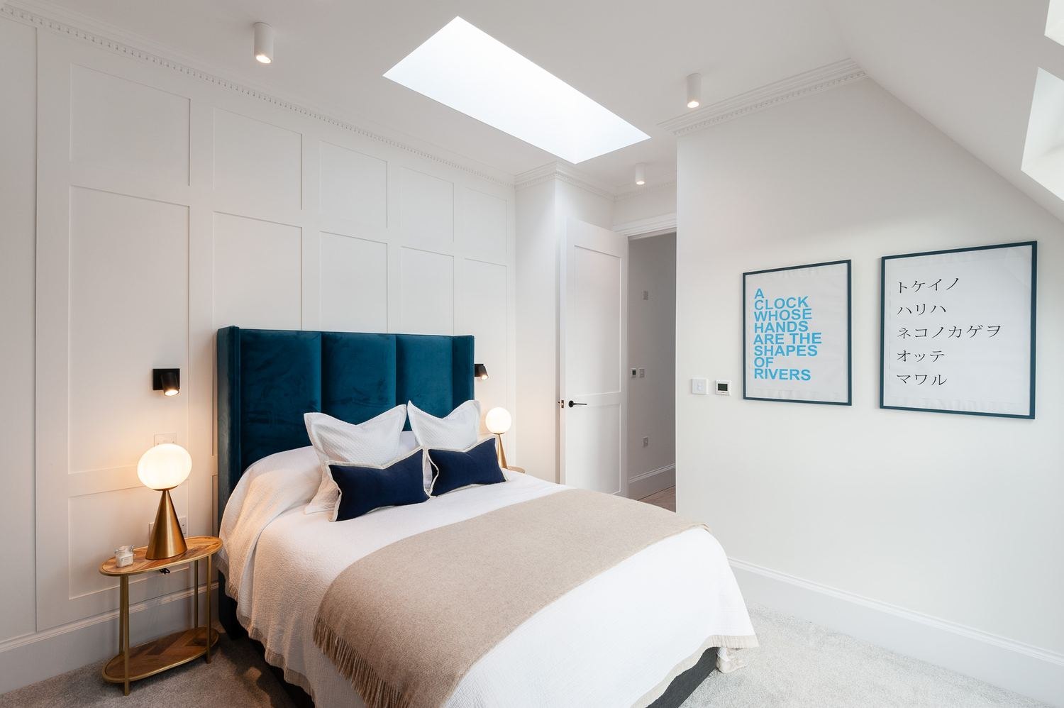 West Lodge bedroom with teal headboard, artwork and rooflight, Ealing — interior design by HDEY