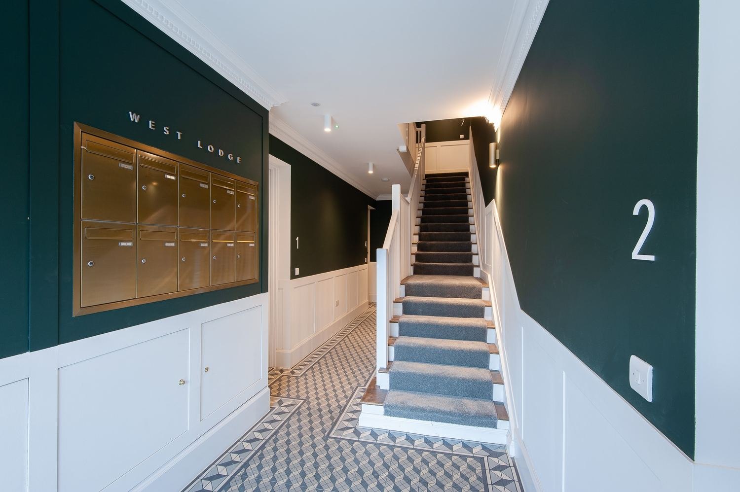 West Lodge communal entrance hall with deep green walls, brass post boxes and mosaic flooring, Ealing — by HDEY
