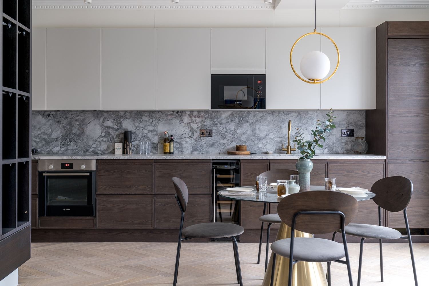 West Lodge kitchen with walnut cabinetry, marble splashback and brass pendant, Ealing — by HDEY