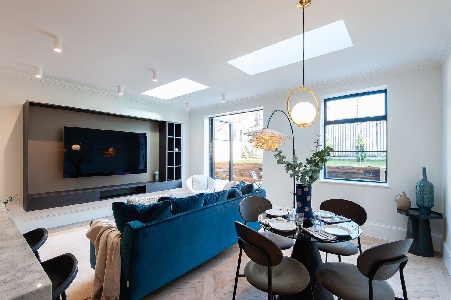 West Lodge living and dining space with media wall and teal sofa, Ealing — interior design by HDEY