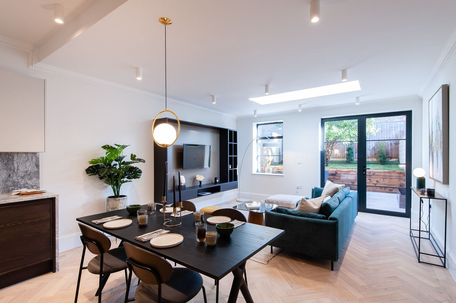 West Lodge open-plan living and dining with teal sofa and garden doors, Ealing — interior design by HDEY