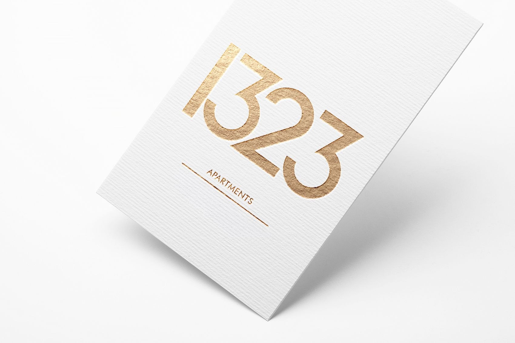 1323 Whetstone brochure cover with the numerals foiled in gold on white textured stock, print design by HDEY