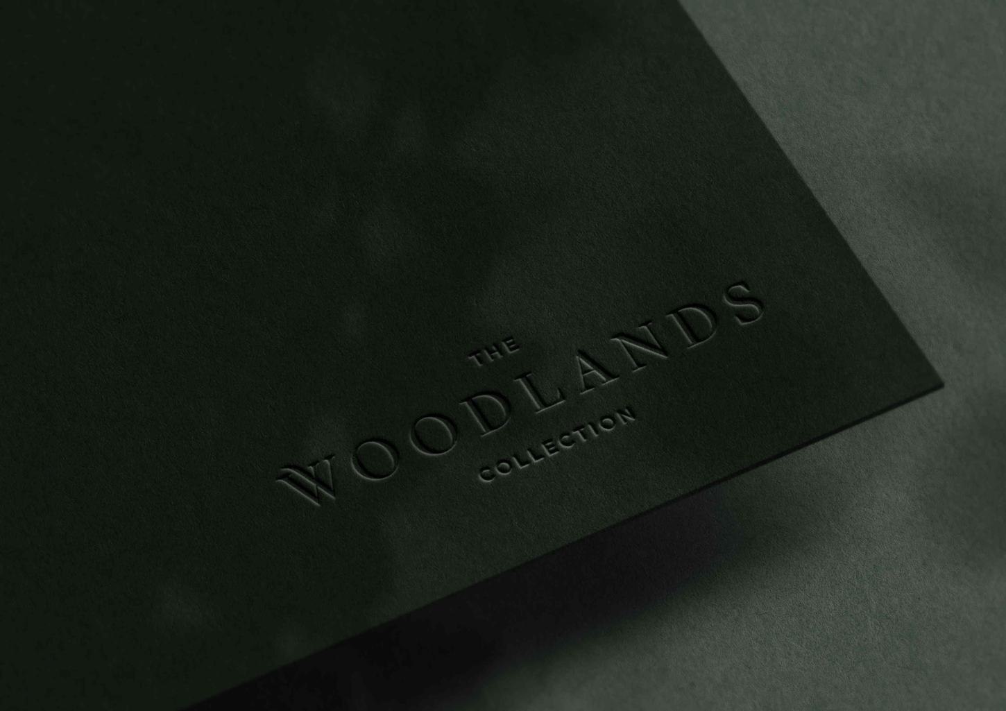 The Woodlands Collection logo debossed on green board, brand identity by HDEY